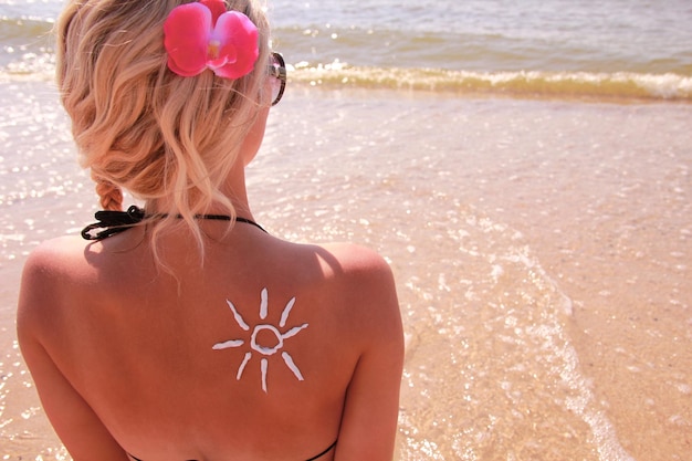 Niña feliz en el hombro del sol en la playa en verano en la naturaleza