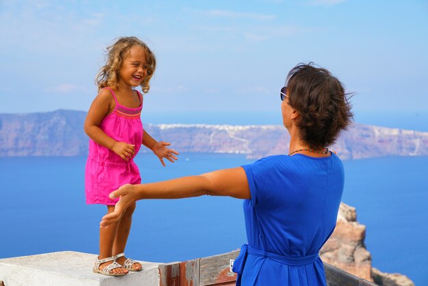 Niña feliz juega con la madre con la vista de la Caldera