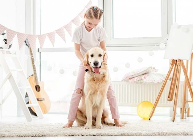 Niña feliz jugando con un hermoso perro