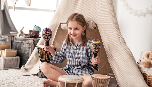 Niña feliz jugando en maracas