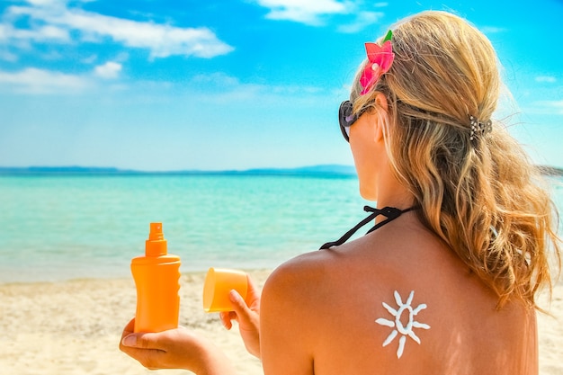 Niña feliz en el mar con una imagen del sol en la espalda