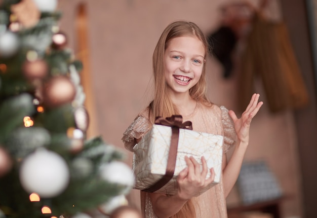 Niña feliz mirando su regalo de Navidad.