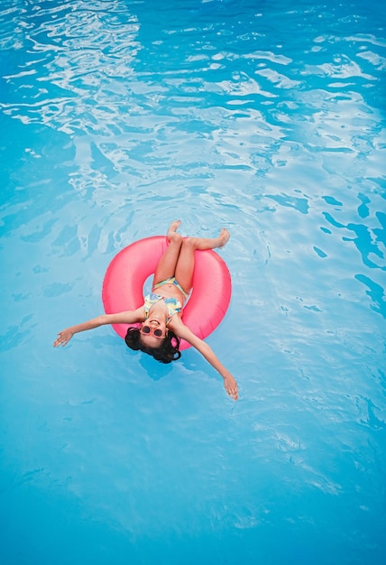 Niña feliz nadando en la piscina