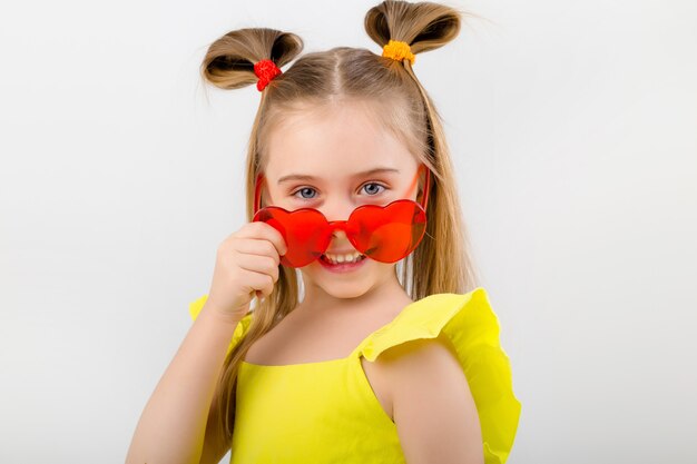 Niña feliz niño en gafas de sol aislar