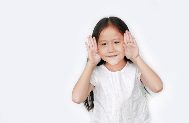 Niña feliz niño gestos jugando peekaboo con espacio de copia. La postura del niño abre las manos de los ojos con una sonrisa.