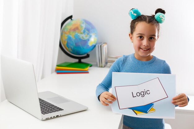 Foto la niña feliz del niño del niño pequeño tiene idea. educación en línea para niños pequeños. kid studding en la computadora portátil