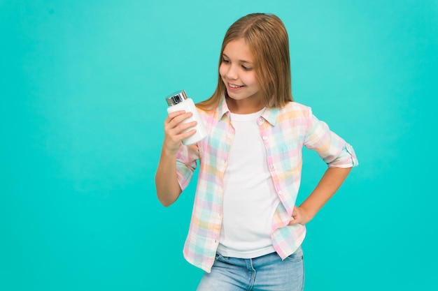 Niña feliz niño con tarro de crema niña sostener vitaminas Belleza y moda niña pequeña con cabello perfecto Infancia felicidad niño pequeño moda Día internacional del niño Belleza pura