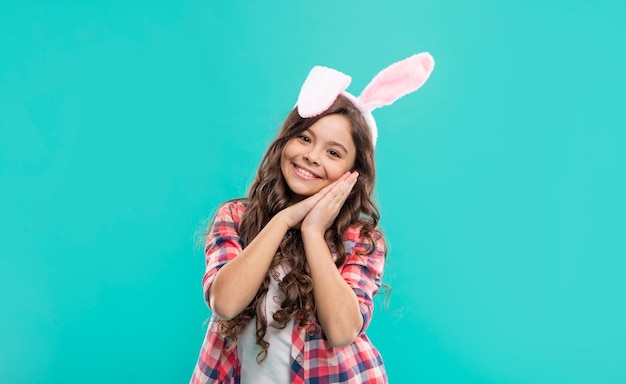 Niña feliz en orejas de conejo de pascua divirtiéndose felices pascuas