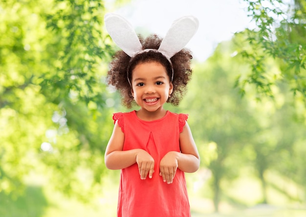 una niña feliz con orejas de conejo de Pascua