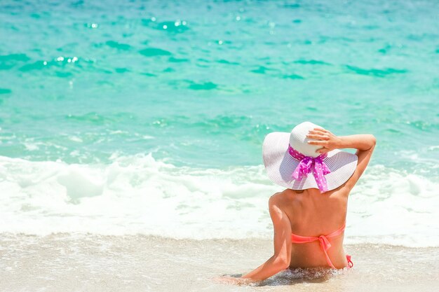 Una niña feliz en la orilla del mar en vacaciones de viaje