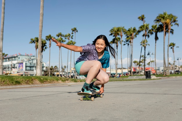 Niña feliz en patineta, divertida actividad deportiva al aire libre