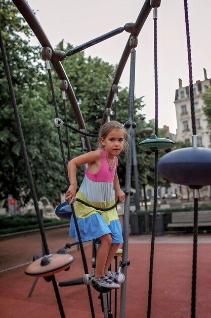 Niña feliz en el patio de recreo en el parque local.