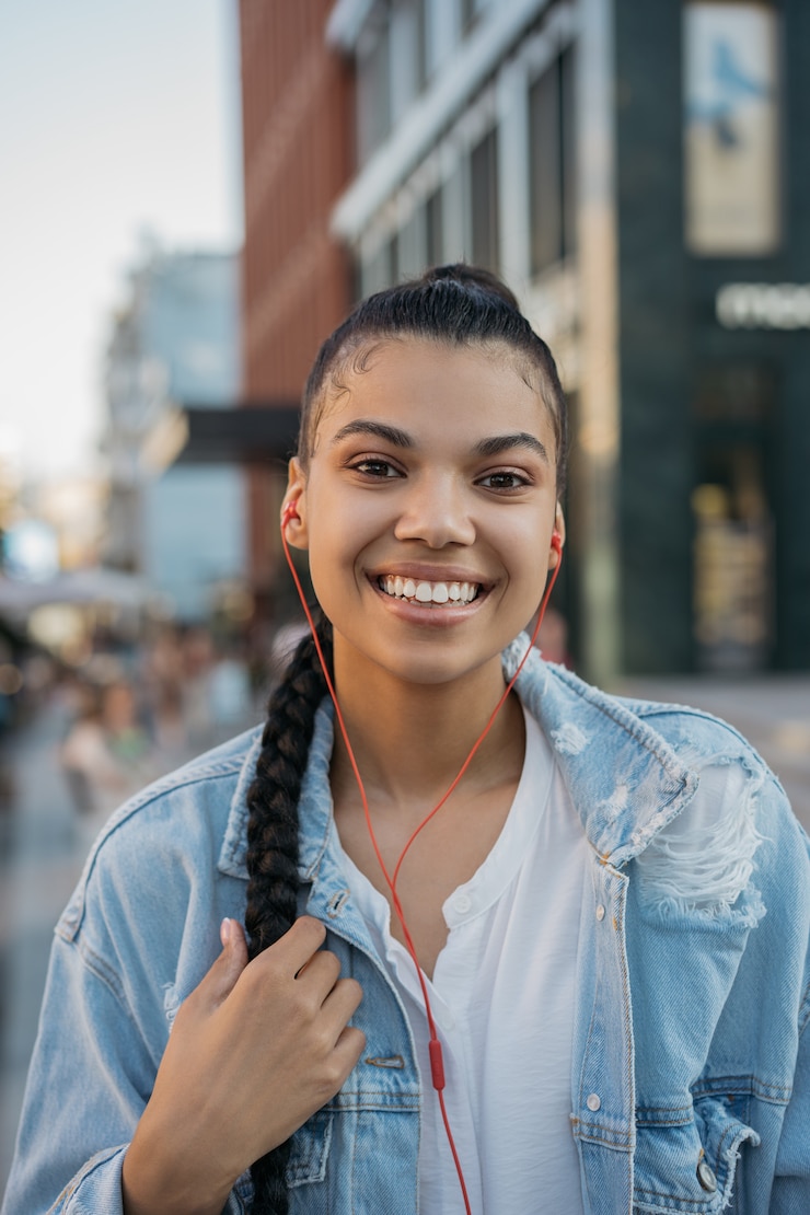 Foto niña feliz con peinado elegante escuchando música al aire libre