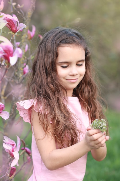 Niña feliz con una pequeña flor de primavera