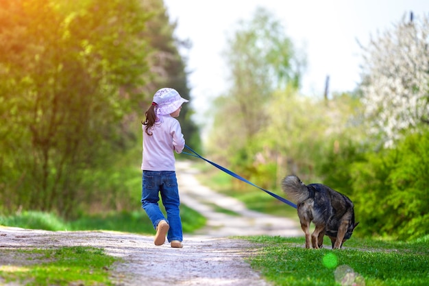 Niña feliz con perro corriendo en el campo