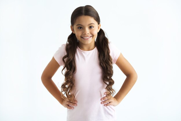 Foto la niña feliz de pie sobre el fondo blanco.