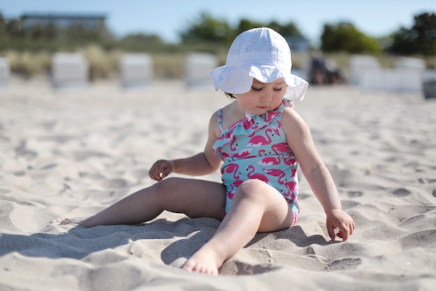 Niña feliz en la playa de arena blanca disfrutando de verano y vacaciones.