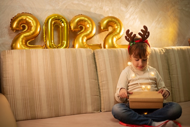 La niña feliz se pone las gafas de Año Nuevo con un árbol y se regocija en la Navidad. concepto de feliz navidad.