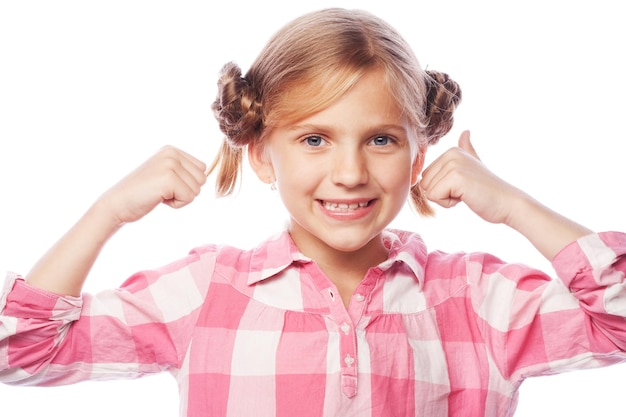 Niña feliz que se encuentra aislada sobre fondo blanco Mirando la cámara mostrando los pulgares hacia arriba Concepto de estilo de vida y personas