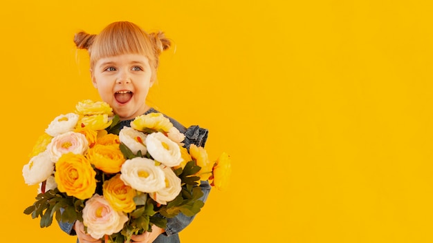 Foto niña feliz con ramo de flores