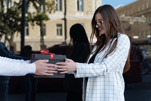 Niña feliz recibe regalo. La mujer joven se sorprendió.