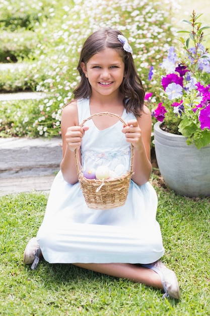 Niña feliz recogiendo huevos de Pascua