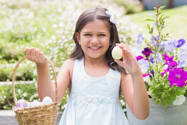 Niña feliz recogiendo huevos de Pascua