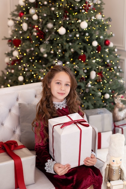 Niña feliz con regalo de Navidad en casa