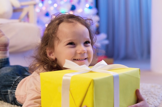 La niña feliz con un regalo en Navidad