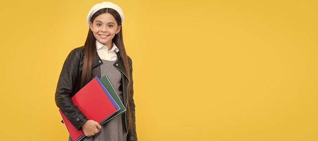 Niña feliz regreso a la escuela sosteniendo libros fondo amarillo Banner de estudiante de escuela Retrato de alumno de colegiala con espacio de copia