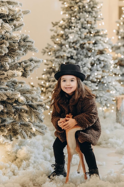 Niña feliz riendo cerca del árbol de navidad