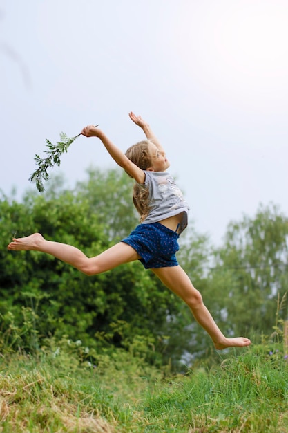 niña feliz salta en el aire en verano