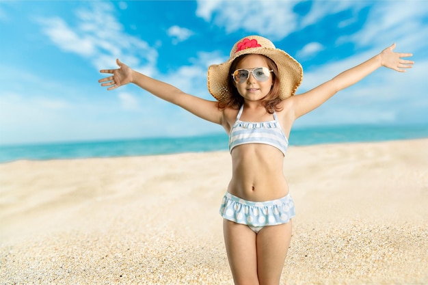 Niña feliz saltando en la playa al amanecer