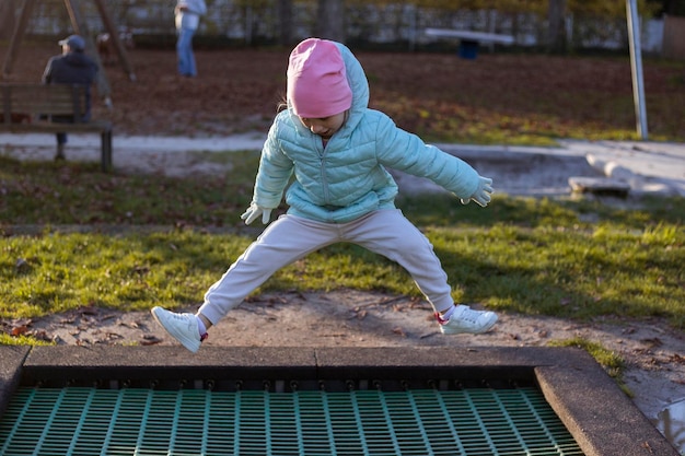 Niña feliz saltando en un trampolín en la calle