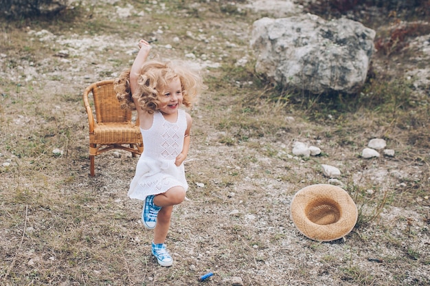 niña feliz en una silla al aire libre