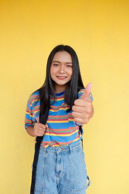 Niña feliz sobre fondo amarillo chica estudiante