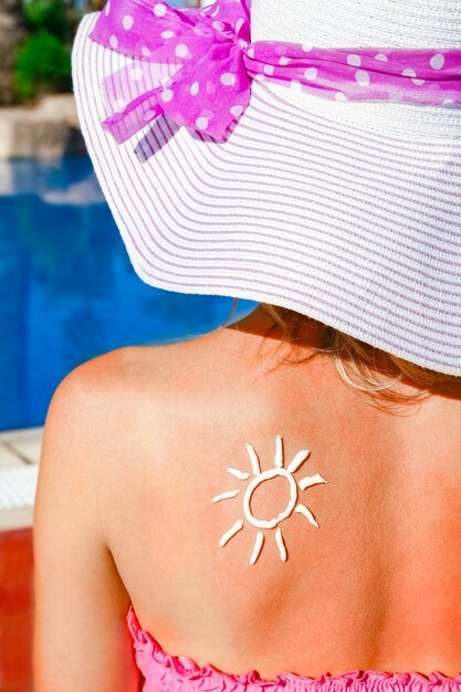 Niña feliz con el sol de espaldas en la piscina en la naturaleza