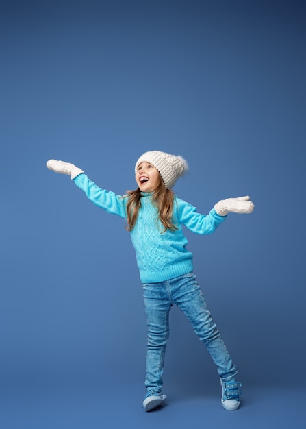 Niña feliz con sombrero y guantes