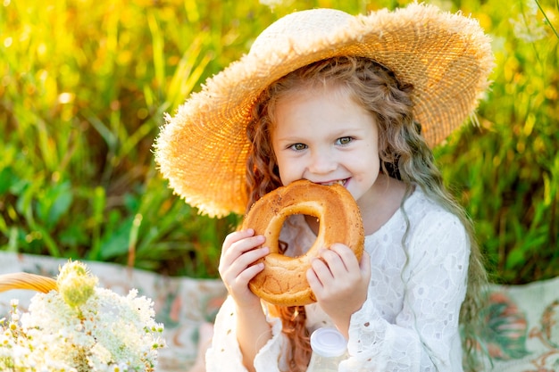 Niña feliz con un sombrero en un picnic