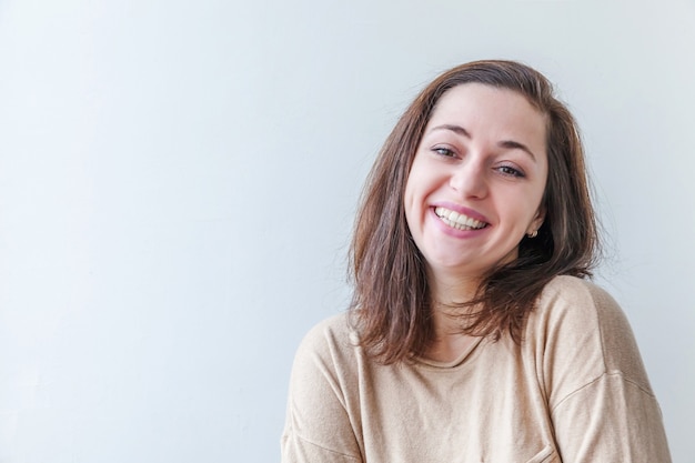 Niña feliz sonriendo. Retrato de belleza joven mujer morena positiva feliz aislada sobre fondo blanco.