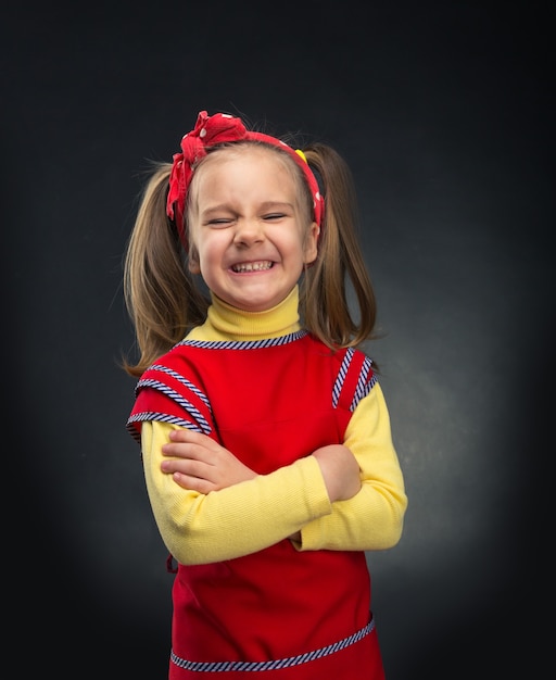 Niña feliz sonriendo sobre fondo gris