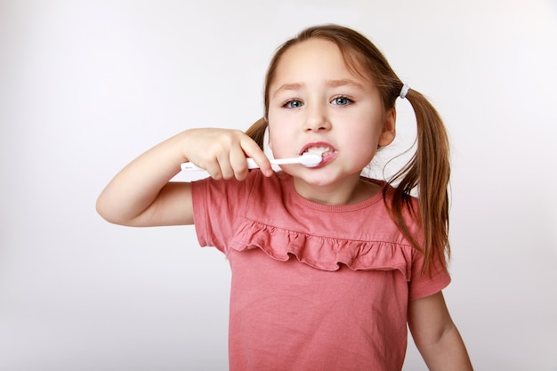 Foto niña feliz sonriente mientras se cepilla los dientes