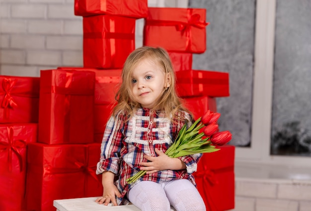 Niña feliz sosteniendo un montón de regalos el día de San Valentín