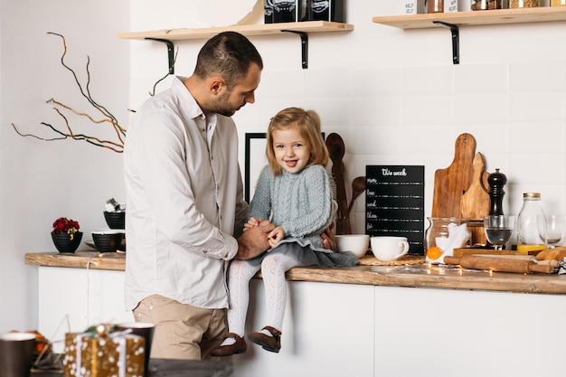 Niña feliz con su padre en la cocina en casa