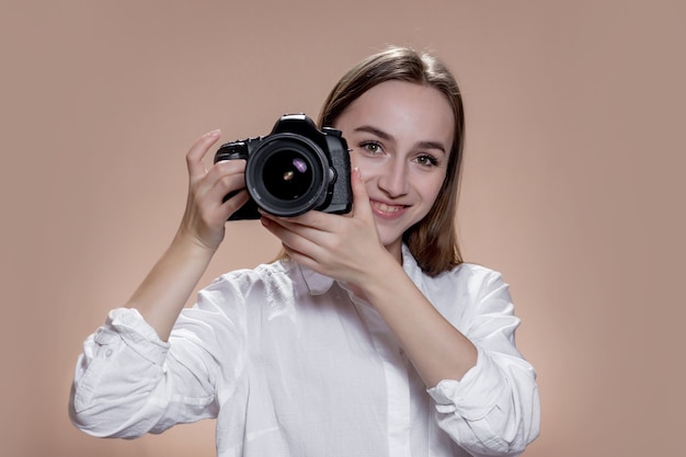 Niña feliz tomando fotografías con cámara digital. Trabajo, gente, afición, estilo de vida, tecnología, concepto de estudio.