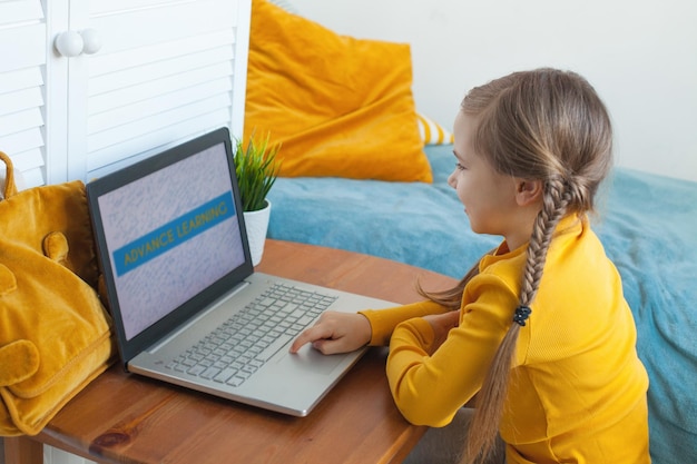 Niña feliz usando una computadora portátil en casa