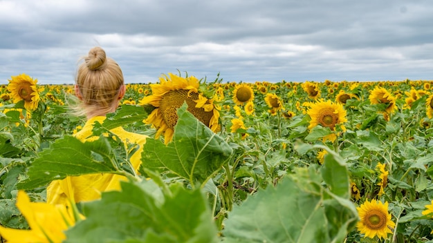 Niña feliz con un vestido amarillo adulto con una apariencia carismática nubes azules en un caluroso día soleado