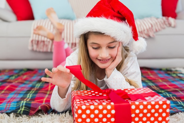 Niña festiva abriendo un regalo