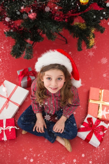 Niña festiva con regalos contra la caída de nieve