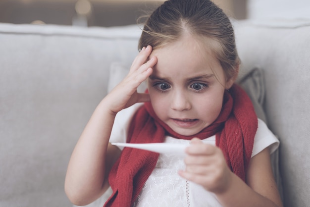 Niña con fiebre sentado en su casa.